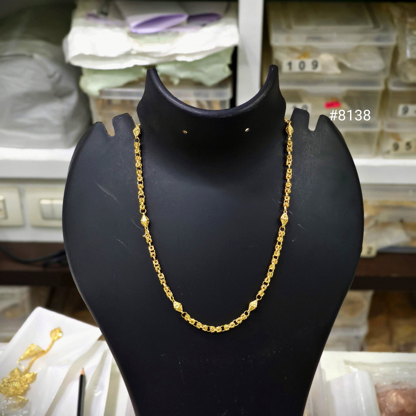 Gold chain on a black mannequin bust with a blurred background