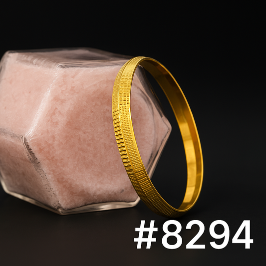 Gold textured bangle leaning against a faceted pink stone block on a dark background, creating an elegant product-style image labeled #8294.