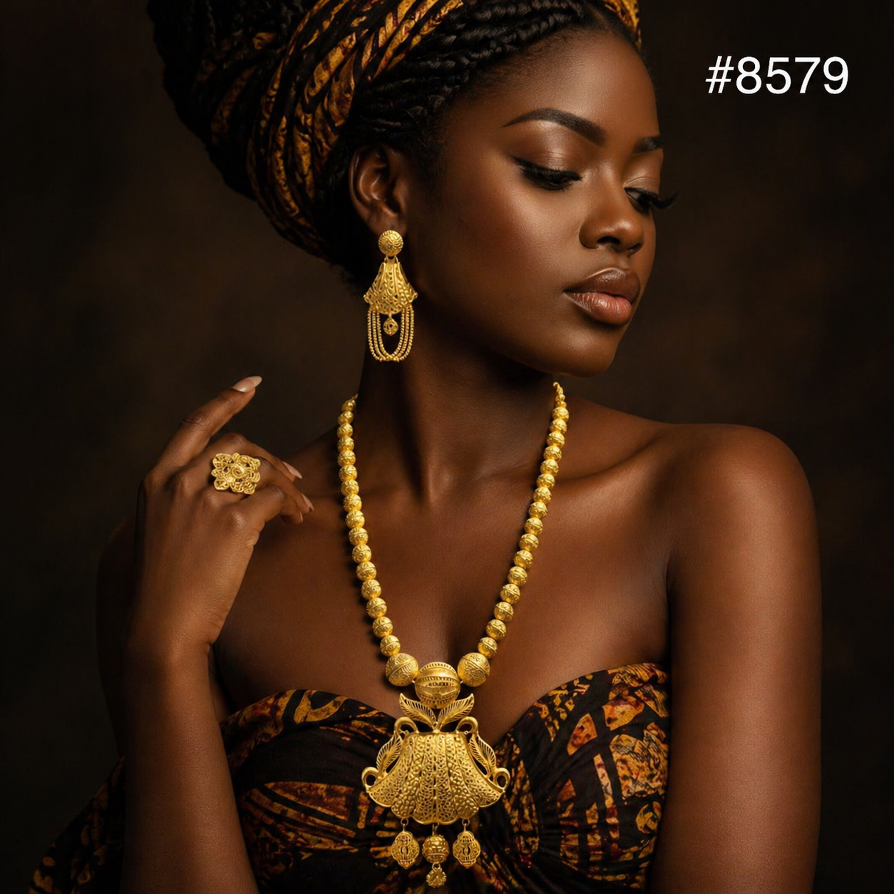 Elegant Black woman in ornate gold jewelry and African print dress, posed against a dark background with braided updo, conveying regal confidence. #8579