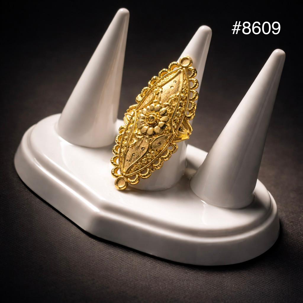 Ornate gold filigree ring with floral and scalloped details displayed on a white three-cone jewelry stand against a dark background; #8609.