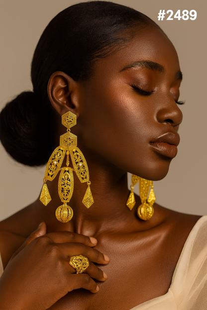 Close-up portrait of a Black woman with closed eyes, ornate gold chandelier earrings and ring, touching a cream drape against a warm backdrop. #2489