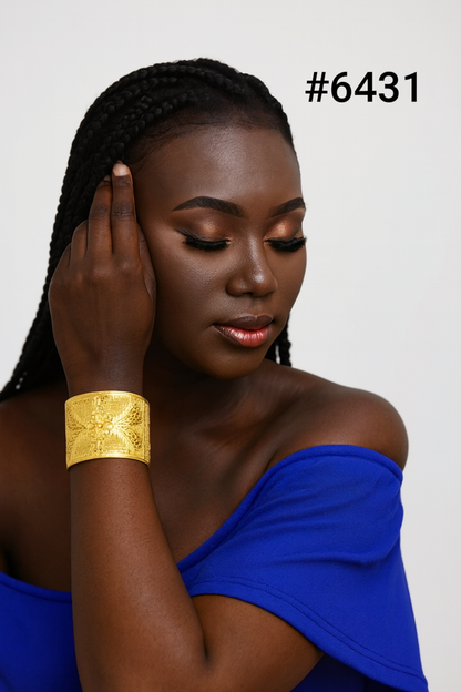 Portrait of a Black woman with braided hair in a royal-blue off-shoulder top and gold cuff bracelet, eyes lowered, calm and elegant; #6431.