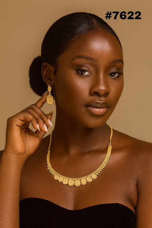 Portrait of a poised Black woman in a strapless black dress, wearing ornate gold jewelry, against a warm brown backdrop; #7622.