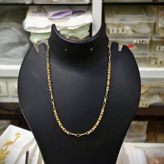 Gold chain necklace on a black mannequin bust with a blurred store background.