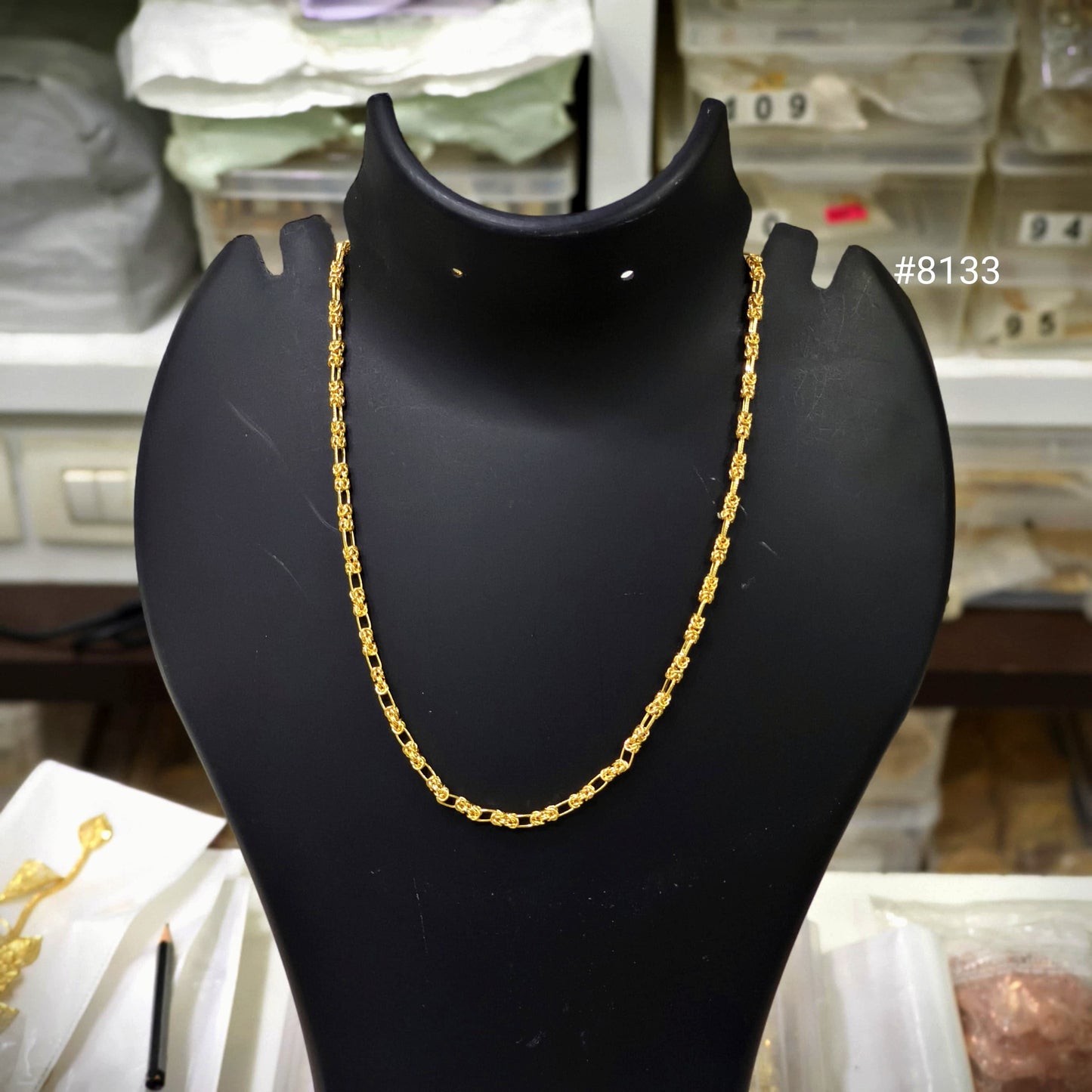 Gold chain on a black mannequin bust with a blurred background