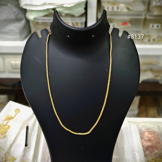 Gold necklace on a black mannequin bust with a blurred background