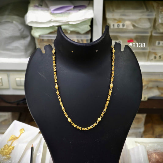 Gold chain on a black mannequin bust with a blurred background