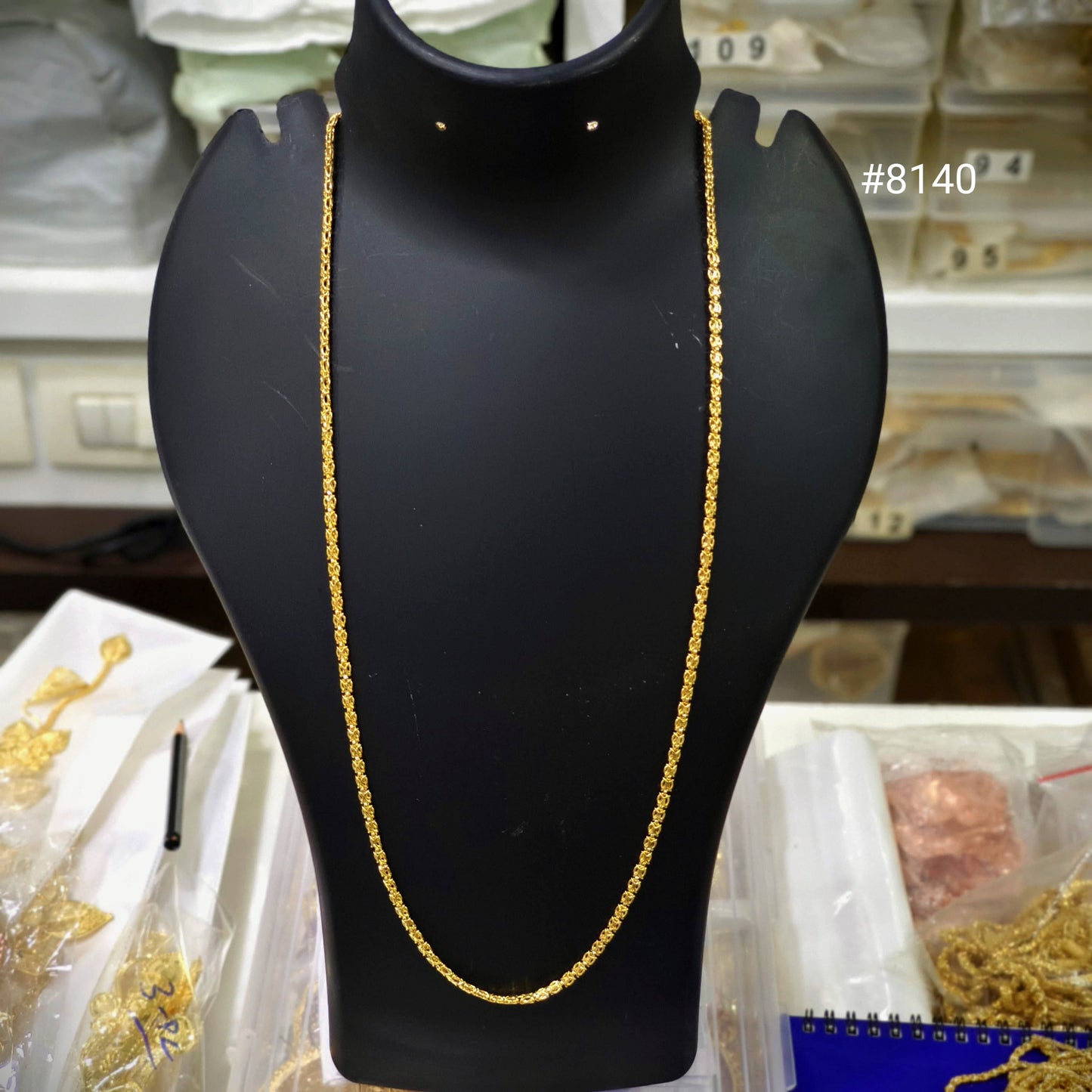 Gold chain on a black mannequin bust with a blurred background