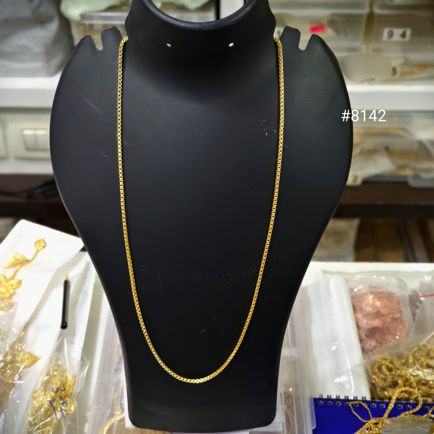 Gold chain on a black mannequin bust with a blurred background