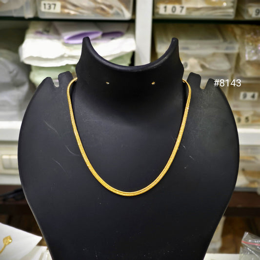 Gold necklace on a black mannequin bust in a store setting