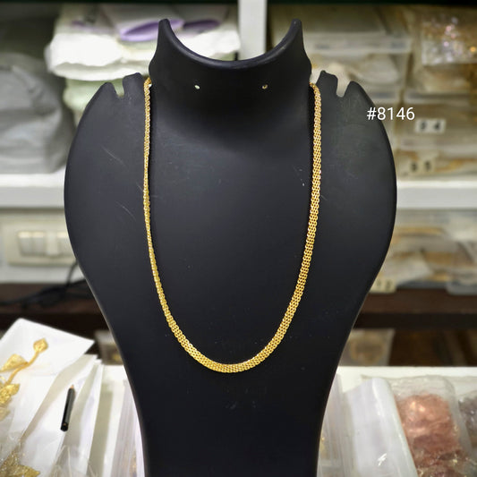 Gold necklace on a black mannequin bust with a blurred background