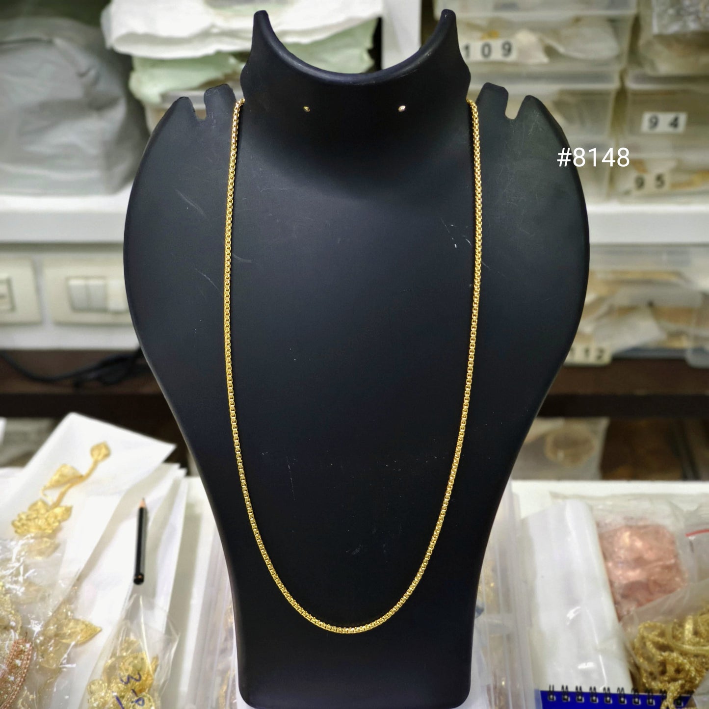 Gold chain on a black mannequin bust with a blurred background