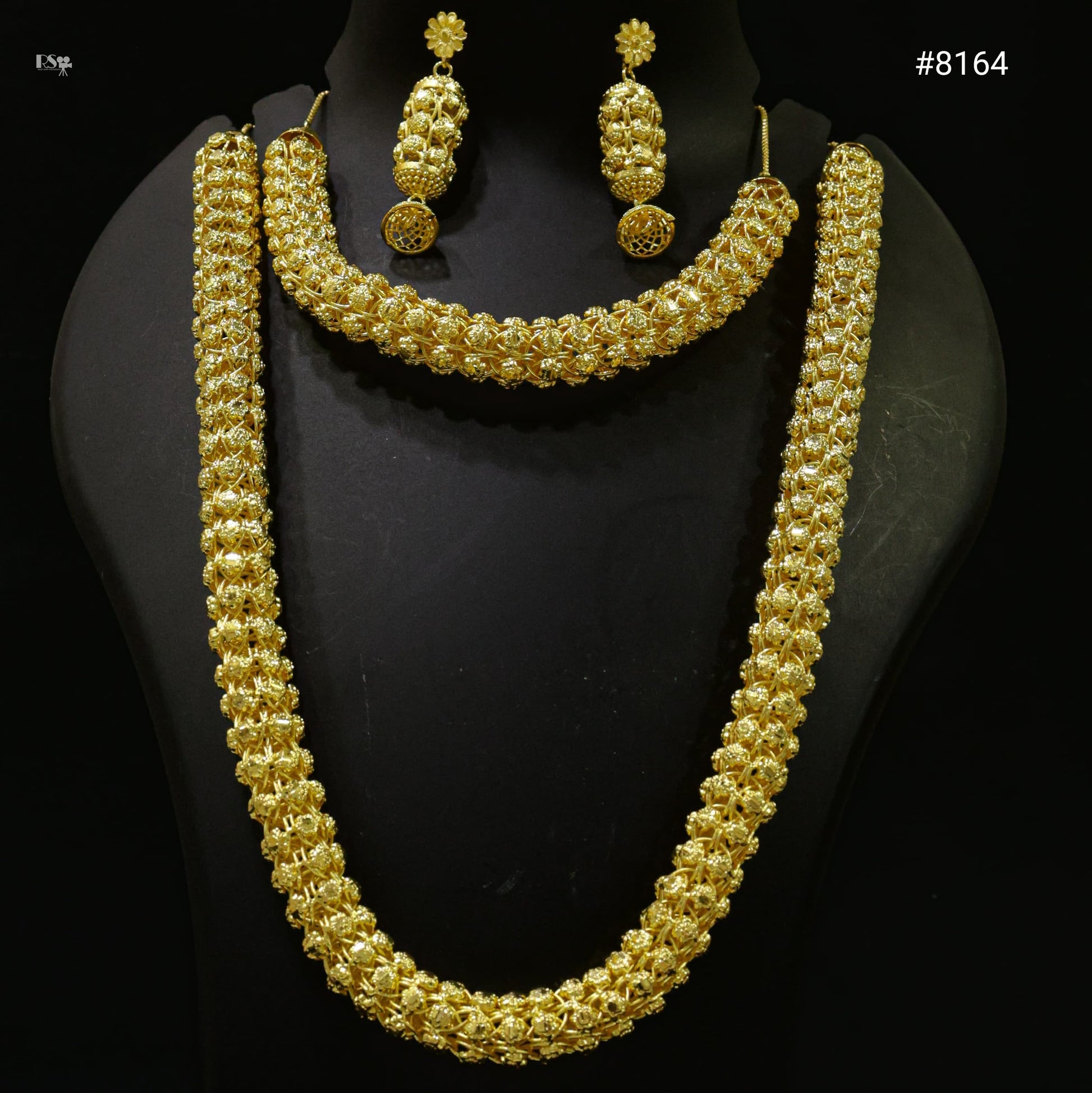 Gold necklace and earrings set on a black mannequin