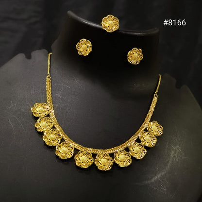 Gold necklace and earrings set on a black background