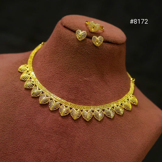 Gold necklace and earrings on a brown velvet stand with a dark background