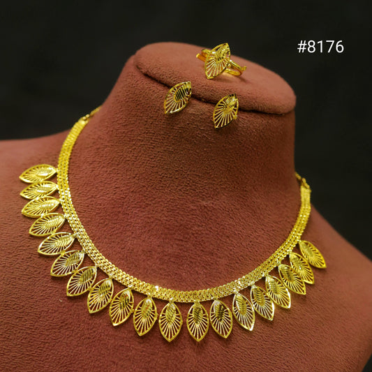 Gold necklace and earrings set on a brown velvet stand with a dark background.