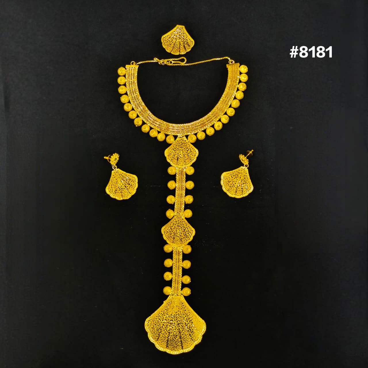 Gold necklace and earrings set on a black background