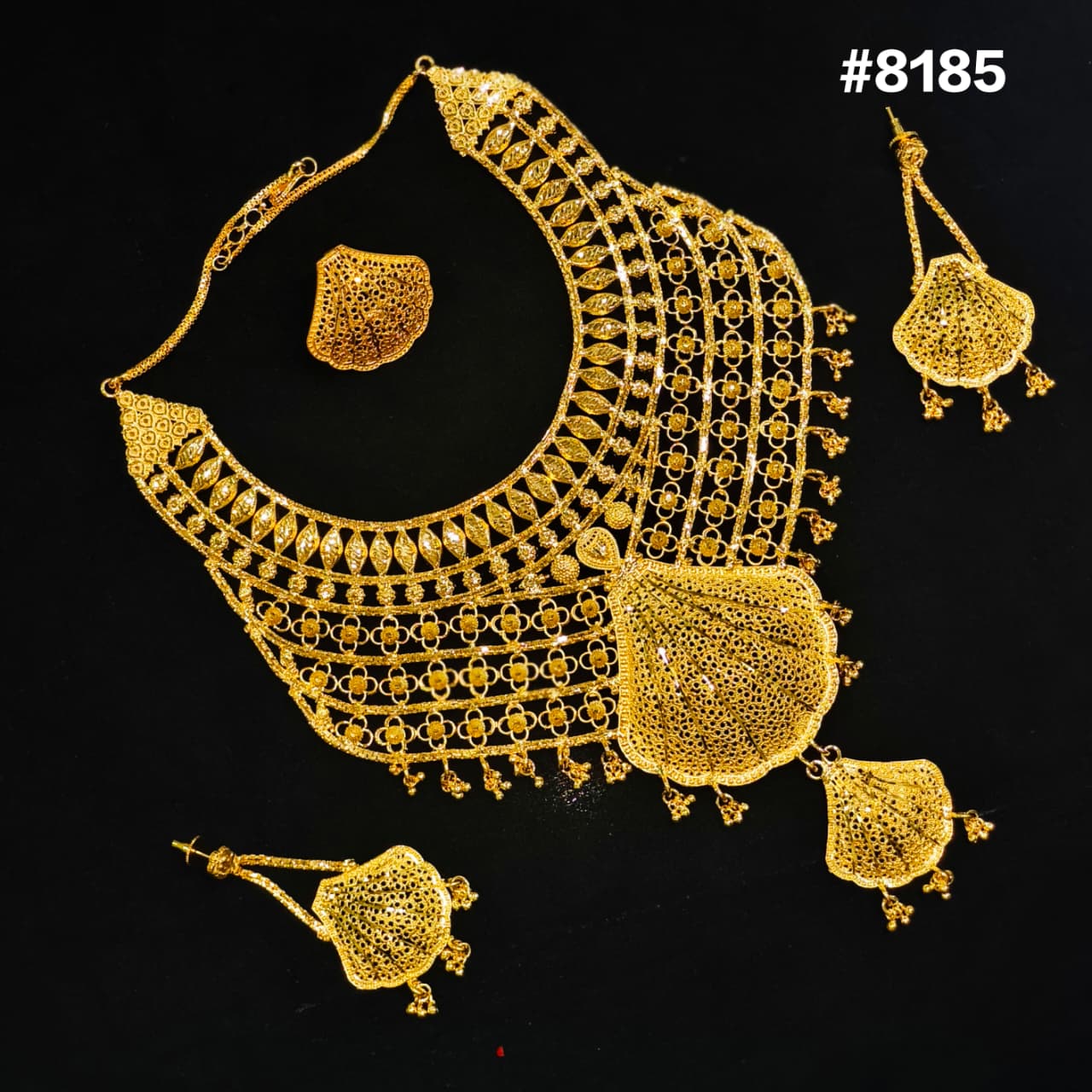 Gold necklace and earrings set on a black background