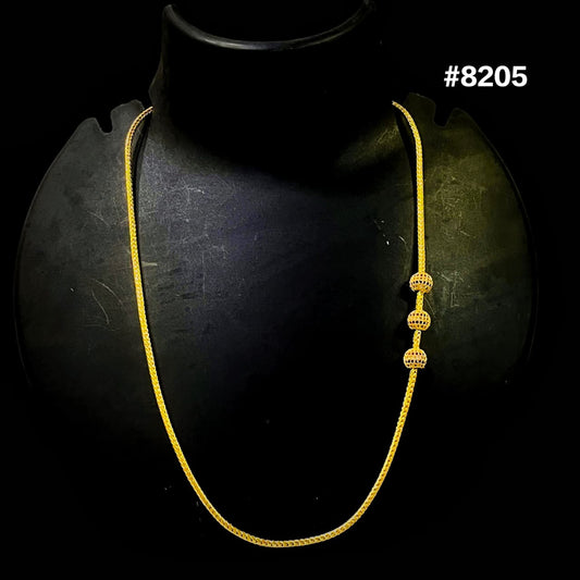 Gold necklace on a black mannequin with a dark background