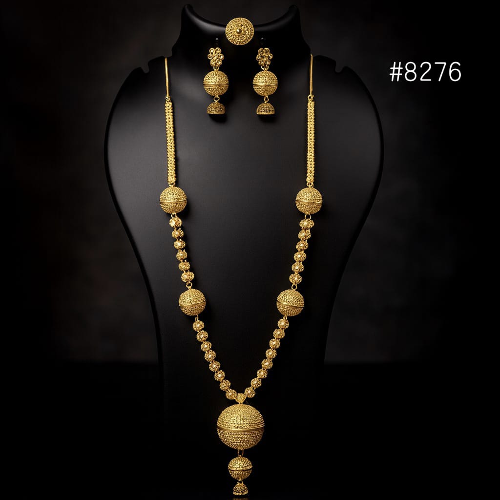 Gold necklace and earrings set on a black mannequin with a dark background.