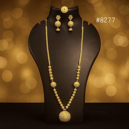 Gold necklace and earrings on a black stand with a blurred gold background