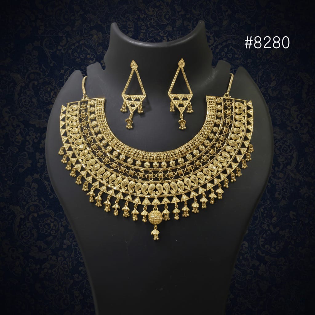 Gold necklace and earrings set on a black mannequin against a dark background