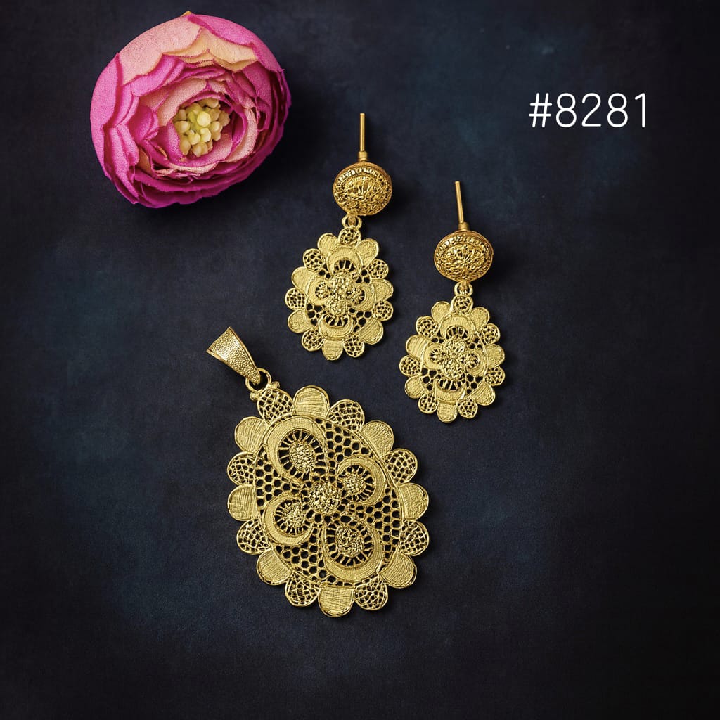 Gold jewelry set with pendant and earrings on a dark background