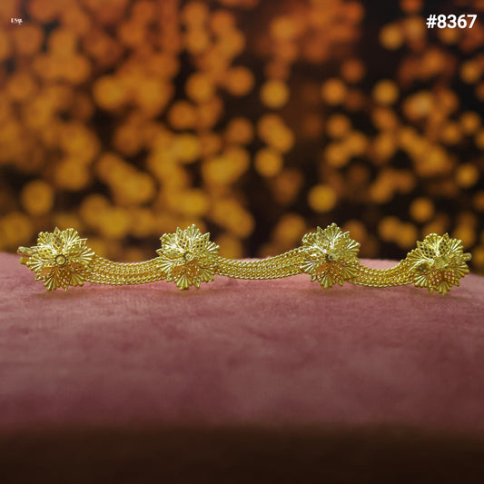 Gold decorative item on a pink surface with a blurred orange background