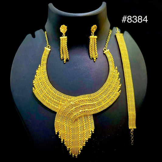 Gold necklace, earrings, and bracelet set on a black background