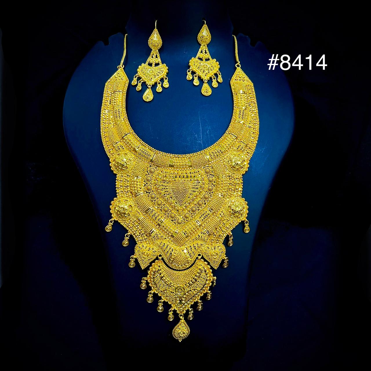 Gold necklace and earrings set on a blue background
