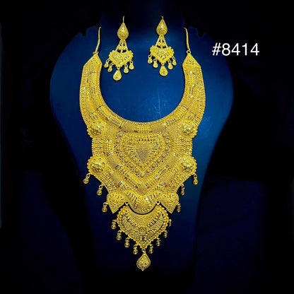 Gold necklace and earrings set on a blue background