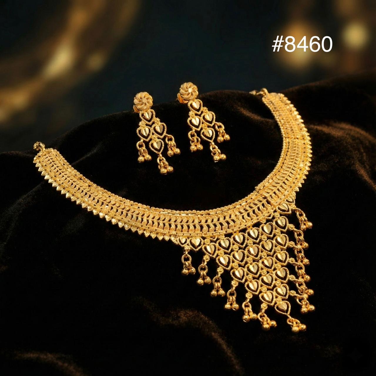 Gold necklace and earrings on a dark background