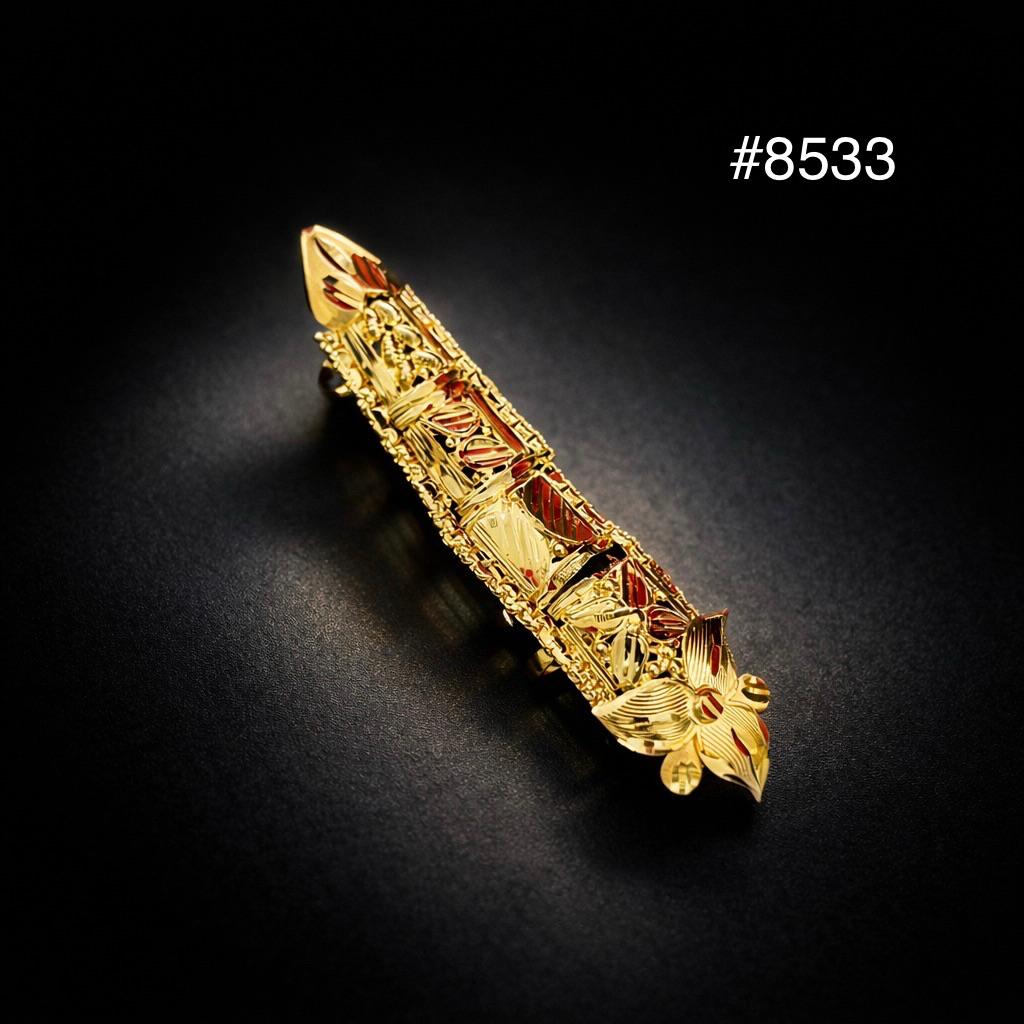 Decorative gold object with red accents on a black background