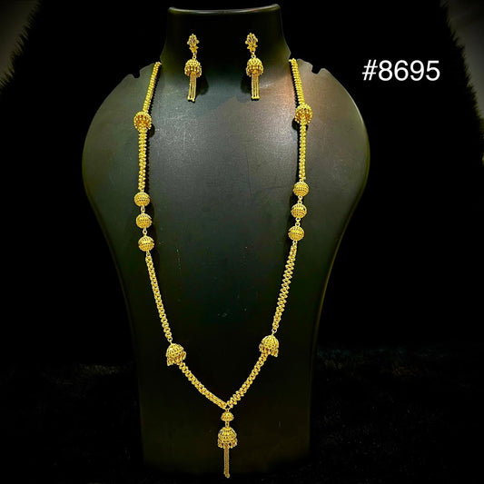 Gold jewelry set with a long ornate necklace and matching dangling earrings on a black mannequin bust; elegant product photo, #8695.