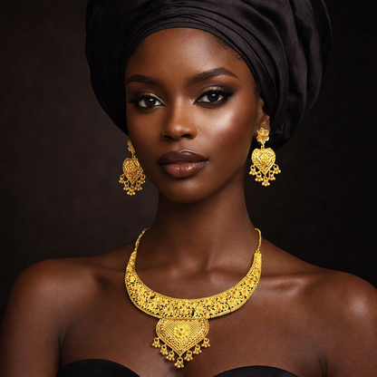 Woman wearing a black headwrap and elegant gold jewelry, including ornate earrings and a matching necklace, set against a dark background.