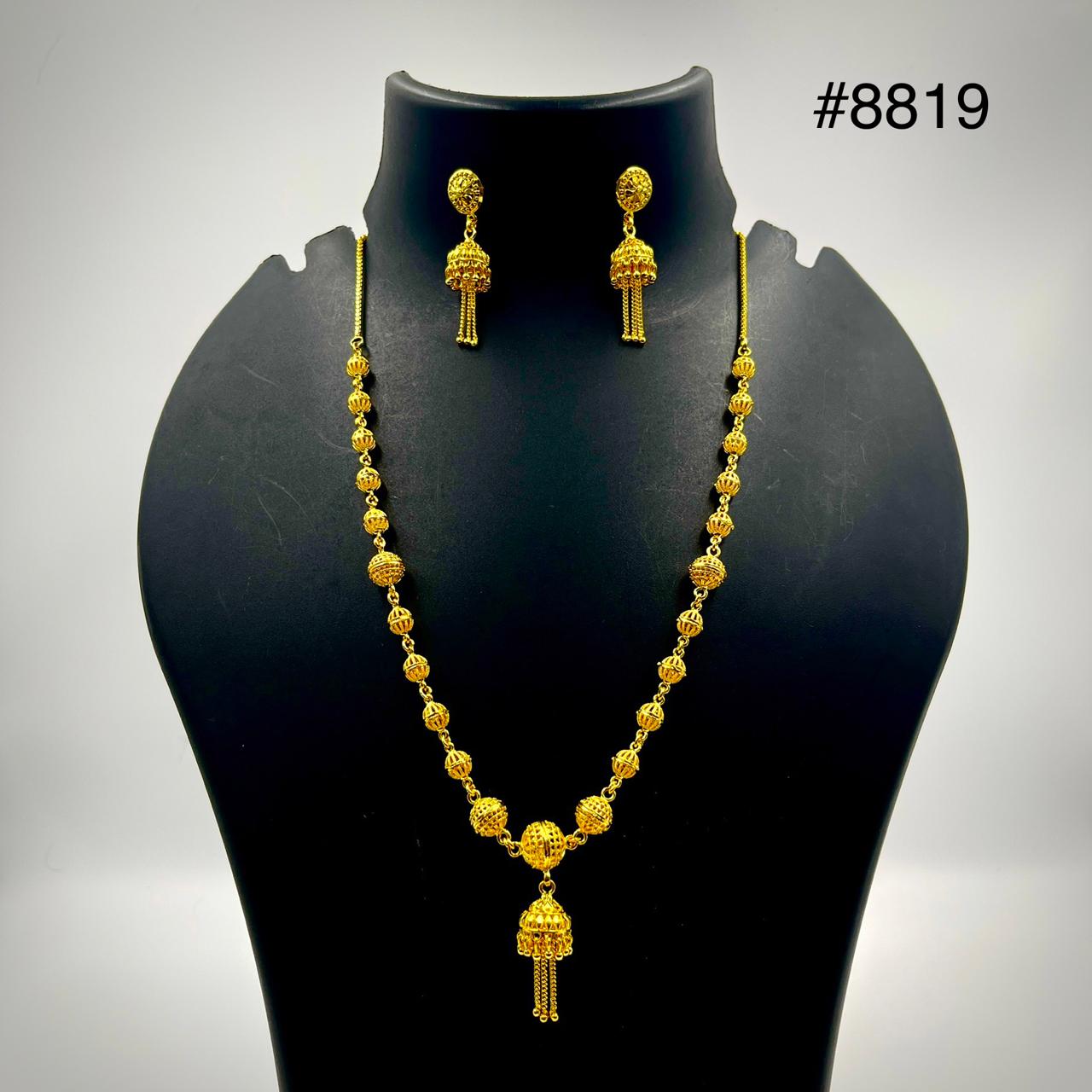 A gold jewelry set displayed on a black stand, featuring a necklace with intricate beadwork and a pendant, accompanied by matching dangling earrings. The number #8819 is shown in the top right corner.