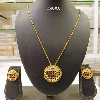 A gold-plated Indian traditional pendant and earrings set displayed on a mannequin bust.
