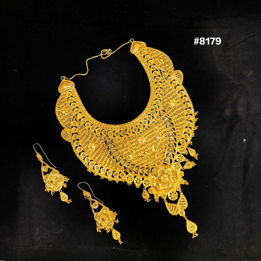 Gold necklace and earrings set on a black background