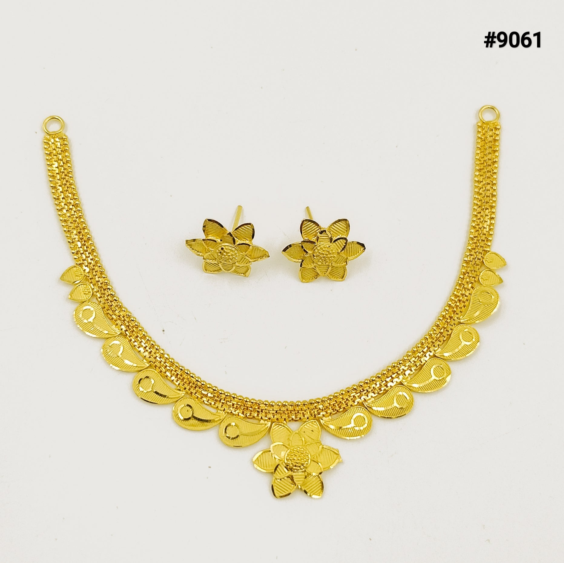 Gold-tone floral necklace with scalloped dangling charms and matching flower earrings, displayed on white; ornate, elegant jewelry set.